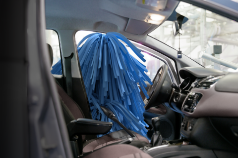 Wascotteis een auto aan de binnenkant aan het stofzuigen.